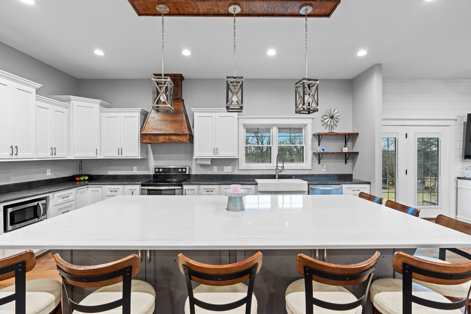 Bright modern kitchen with island and wood range hood