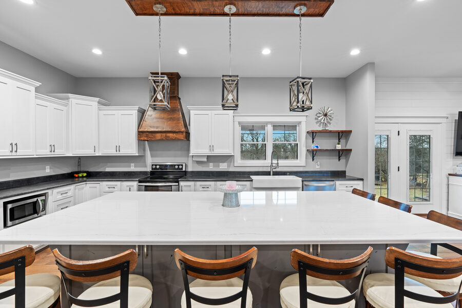 Bright modern kitchen with island and wood range hood