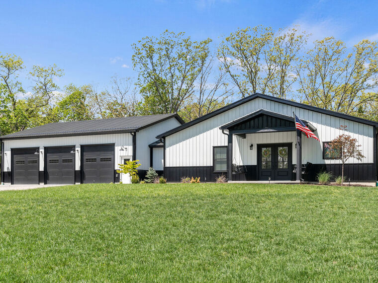 Black and white barndominium on open acreage