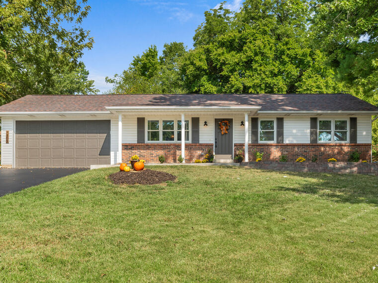 Brick ranch home with attached garage and mature shade trees