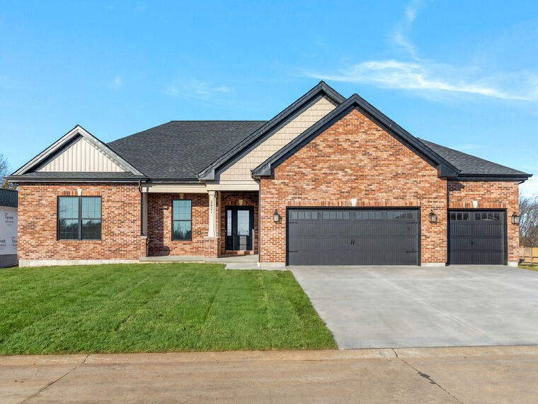 Brick ranch home with stone accents and a three-car garage